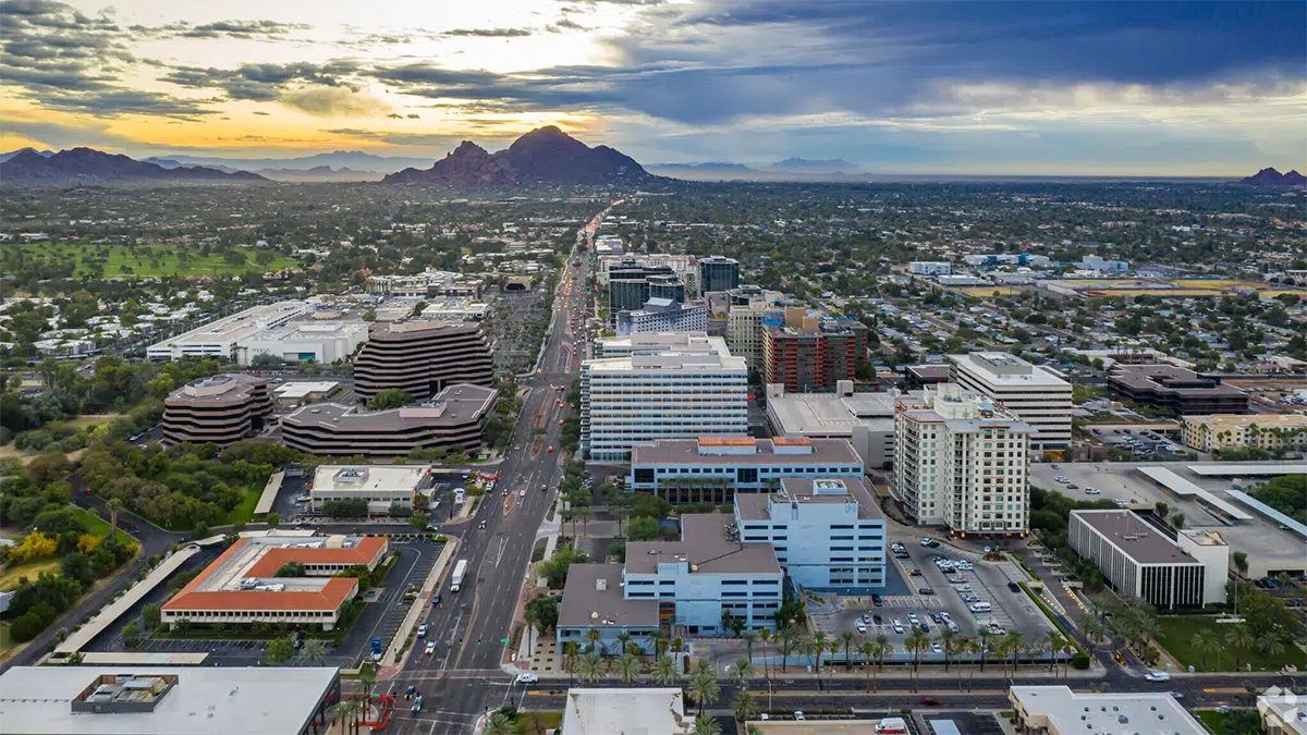 Aerial view of the Camelback Corridor business district in Phoenix, Arizona, with Camelback Mountain in the background at sunset.